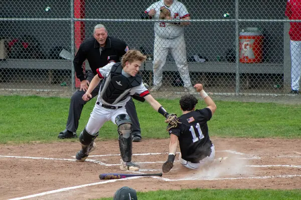 Runner sliding into home plate as catcher applies the tag
