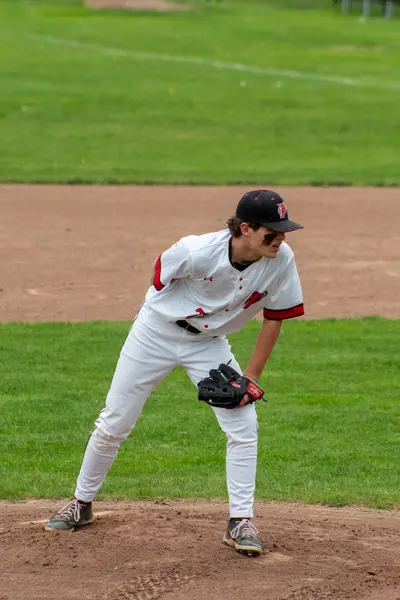 Pomperaug pitcher in his stretch, checking the runner