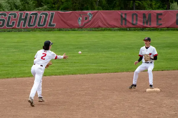Infielder tossing the ball to second base for the force out