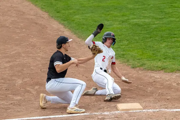 Runner sliding safely into third base