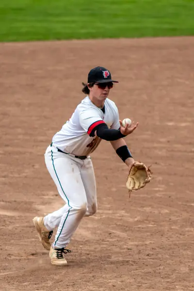Infielder scooping a low throw at first base