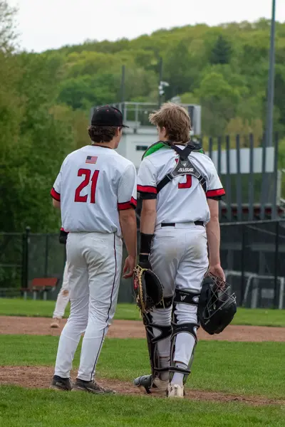 Pitcher and catcher walking back to the mound together