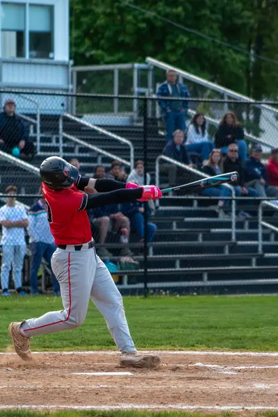 Batter following through on a big swing in front of the crowd
