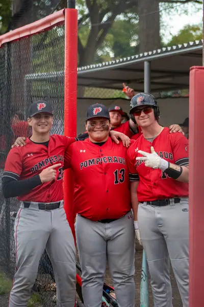 Three Pomperaug teammates posing together by the dugout