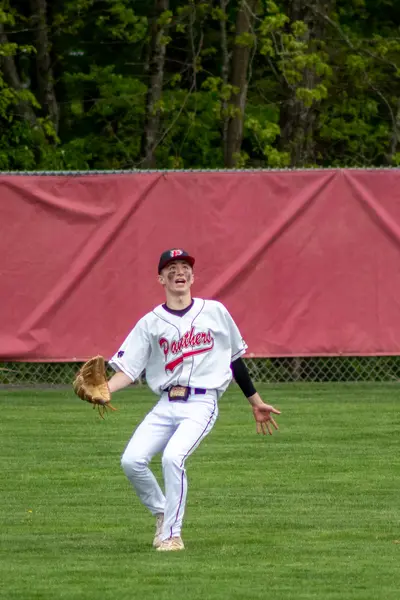 Outfielder tracking a fly ball, mouth open
