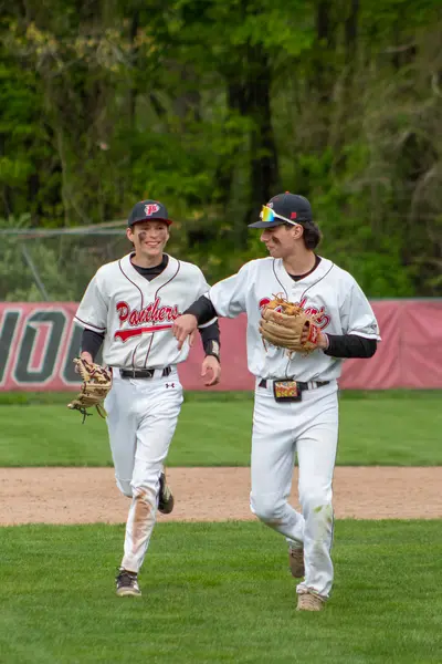 Two teammates jogging in from the outfield together