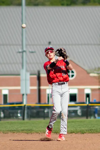 Infielder jumping to make a throw, ball in the air