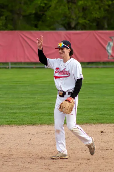 Infielder throwing a peace sign toward the crowd