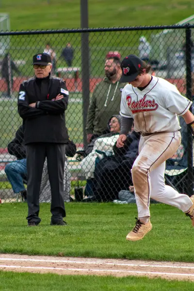 Baserunner jogging past the umpire toward home