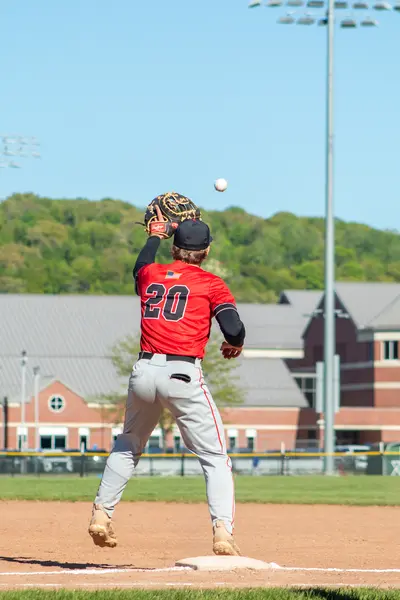 Infielder catching a high throw at third base