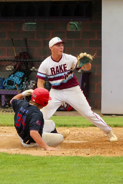 Catcher receiving a pitch as a runner slides into home