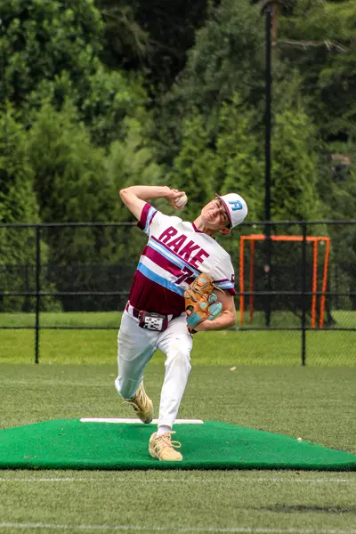 Pitcher mid-delivery, glove tucked at the hip