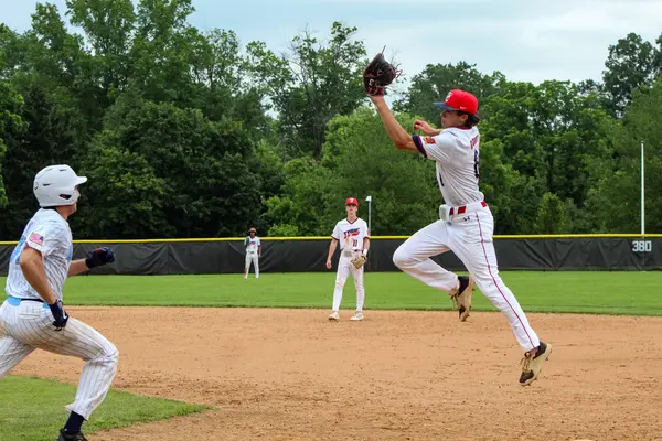 Infielder leaping to make the catch on a throw