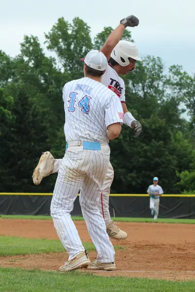 Runner and teammate celebrating after scoring