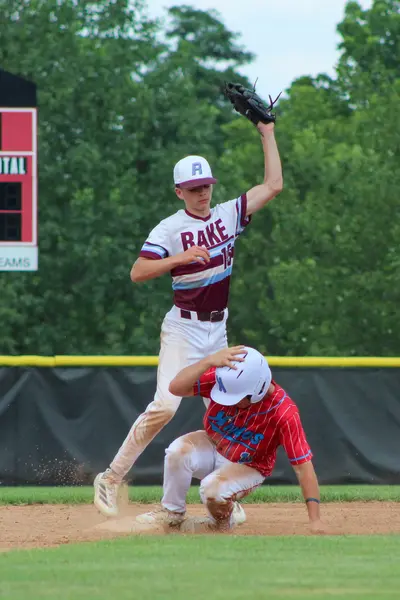 Infielder applying the tag as a runner slides into second