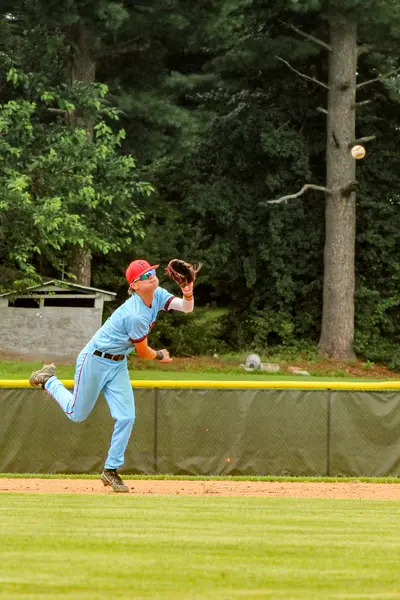 Outfielder hauling in a deep fly ball