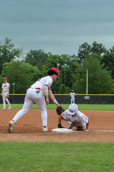 Infielder tagging out a runner diving back to third