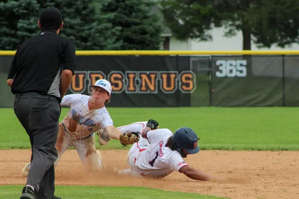 Infielder tagging a sliding runner at second base