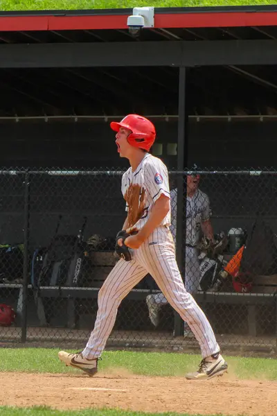 Batter shouting in celebration in the dugout