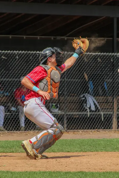 Catcher stretching to snag a high throw
