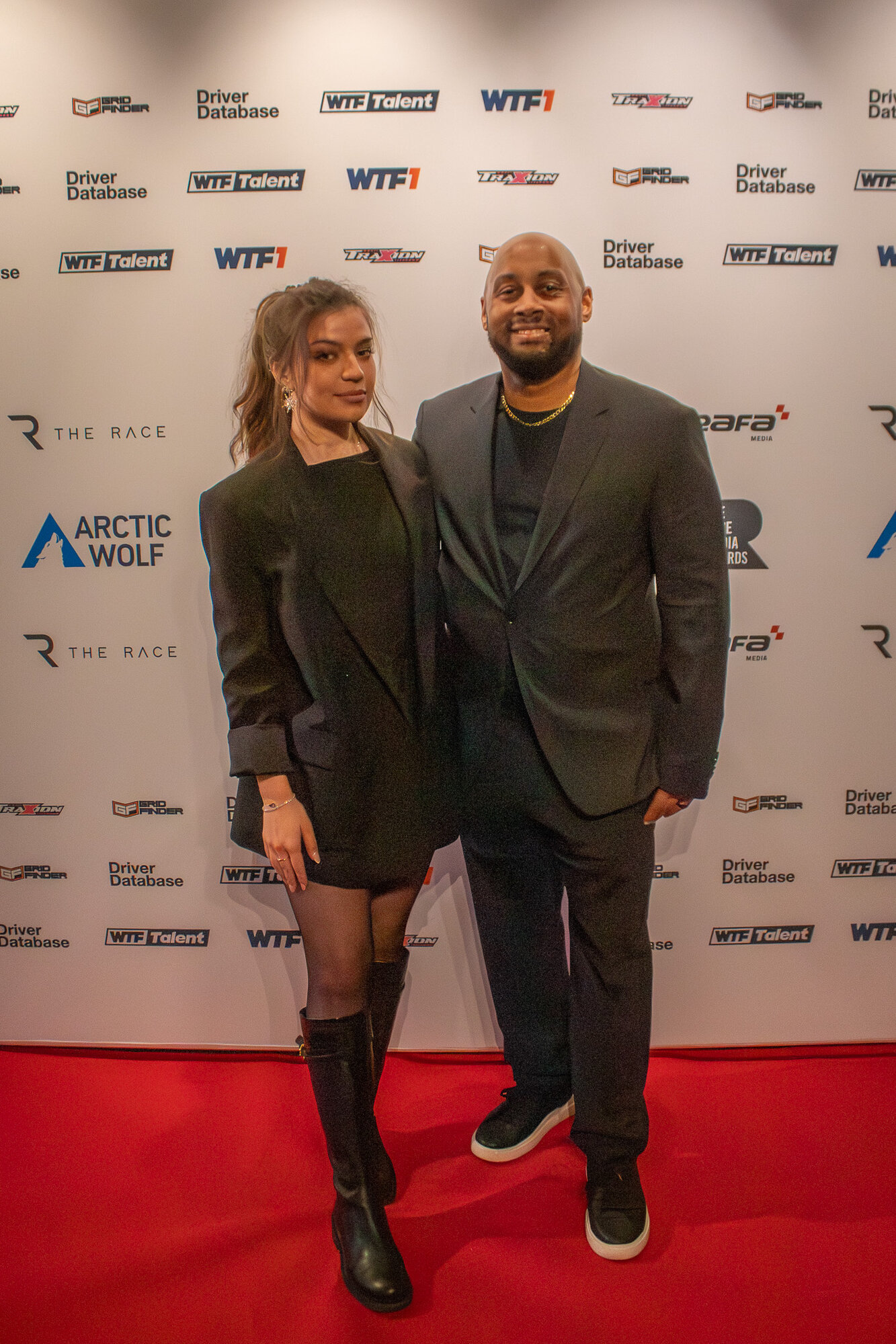 Two guests posing together on the step and repeat