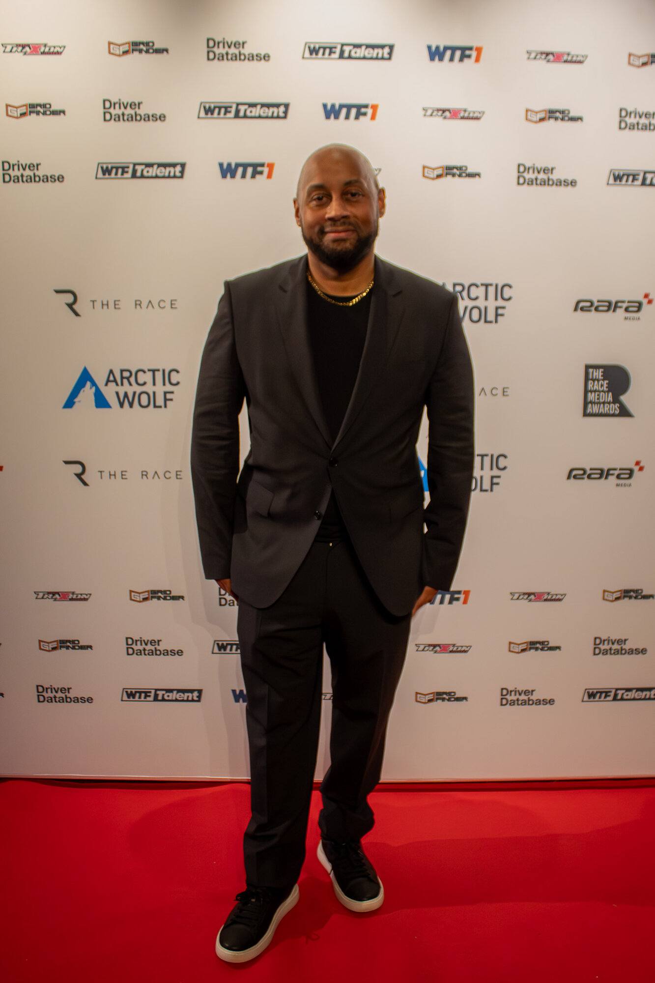 Guest smiling for a solo portrait on the step and repeat