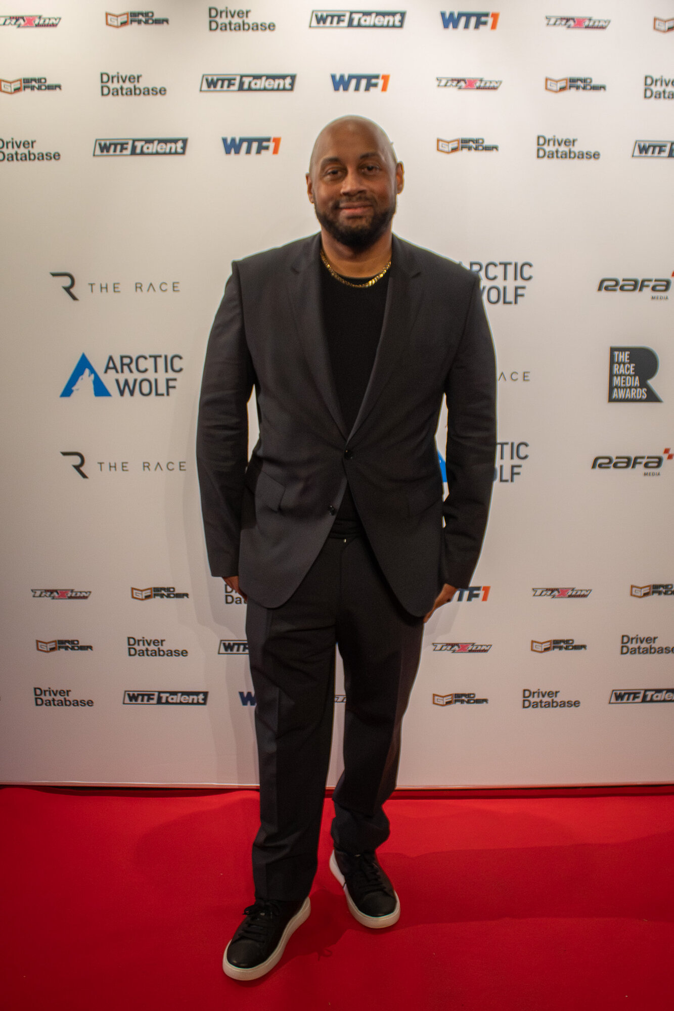Guest smiling for a solo portrait on the step and repeat