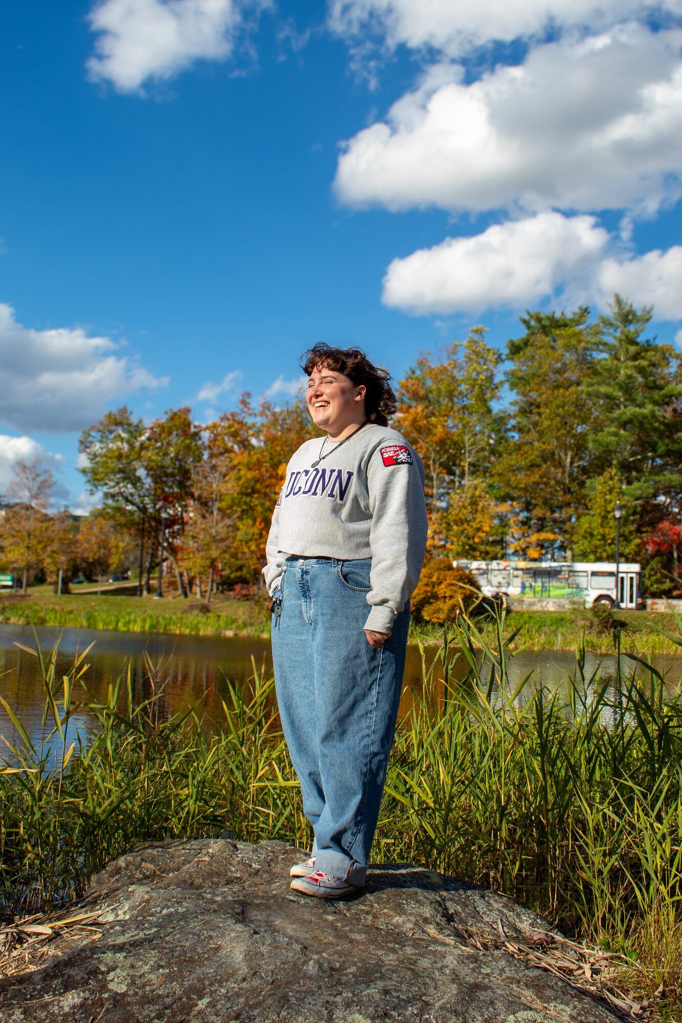 Molly senior portrait, standing on a rock by the pond