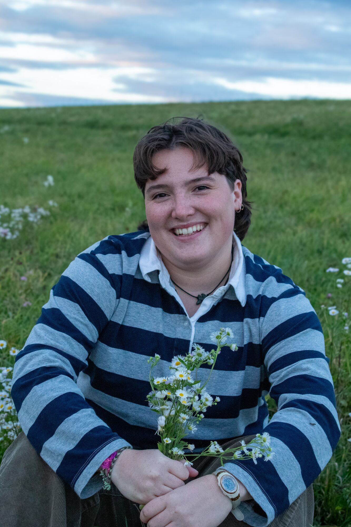 Molly senior portrait, holding wildflowers in the field